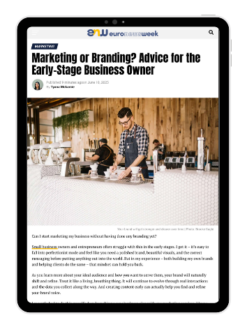 Tablet screen showing the Euronewsweek article “Marketing or Branding? Advice for the Early-Stage Business Owner” by Tyana McKamie, featuring a barista at a counter.